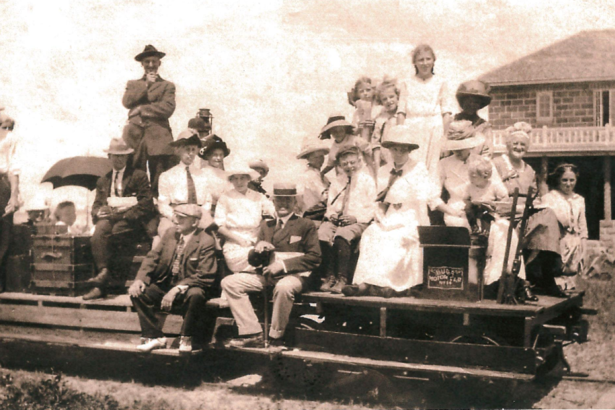 historical photo of men and women on a push car